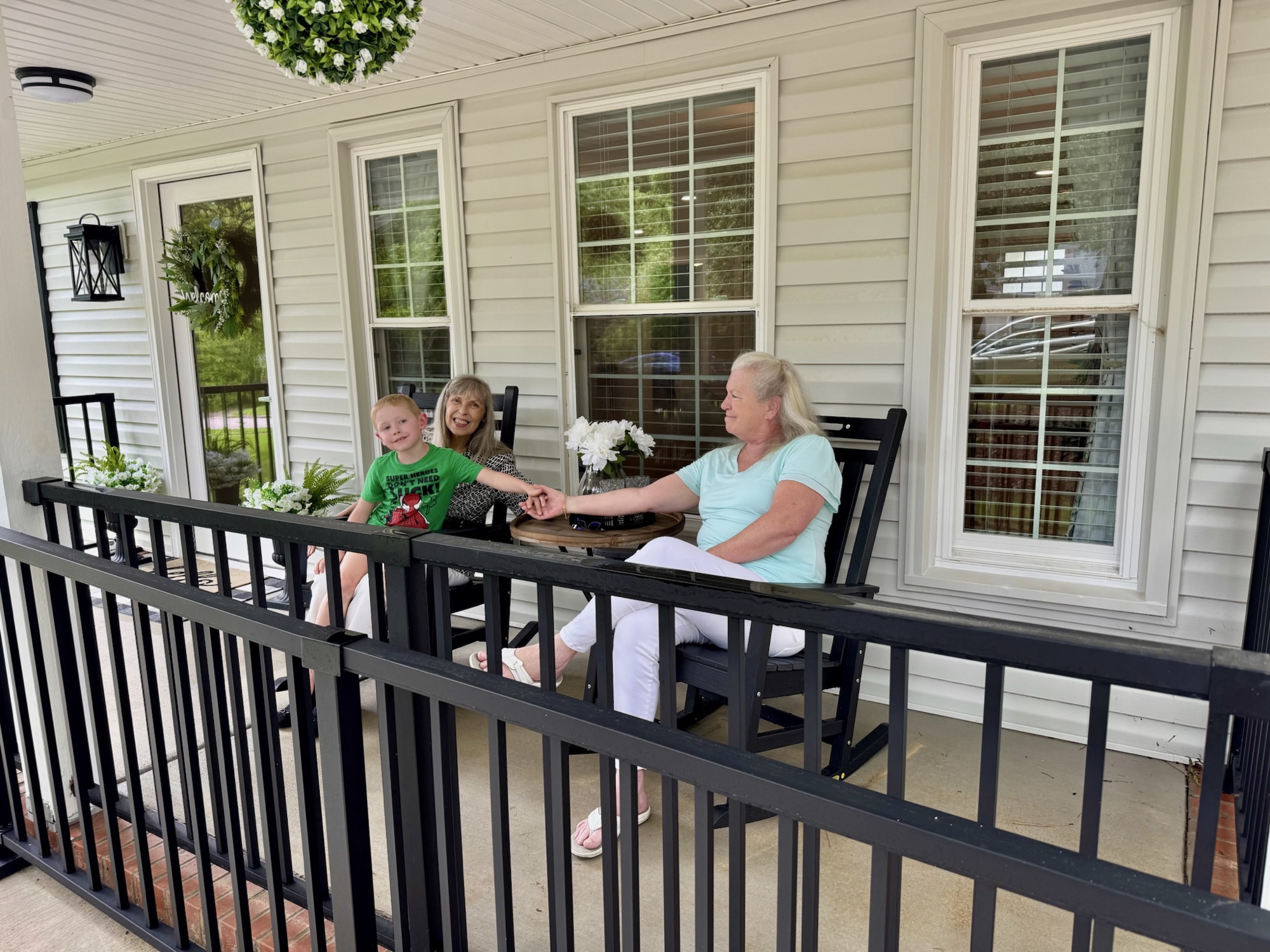 Three generations sitting together on the Picardy Pointe front porch in rocking chairs